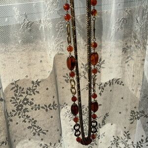 Five strand gold tone beaded necklace with amber plastic beads.